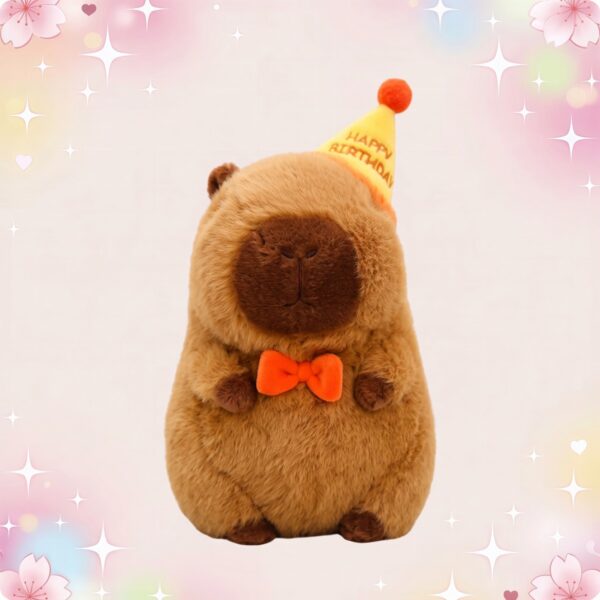 Une peluche kawaii capybara d'anniversaire brune avec un chapeau jaune « Happy Birthday » et un nœud papillon orange, sur fond pastel décoré d'étoiles et de cœurs.