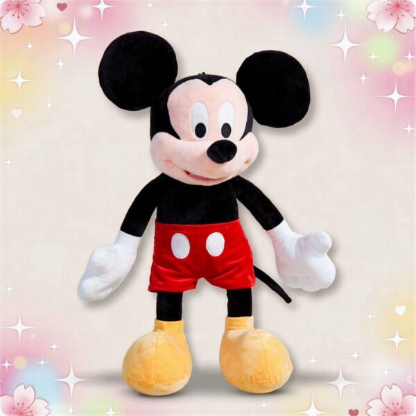 Une grande peluche Mickey debout, avec grandes oreilles noires, gants blancs, short rouge et grosses chaussures jaunes, sur un fond pastel décoré d’étoiles et de cœurs.