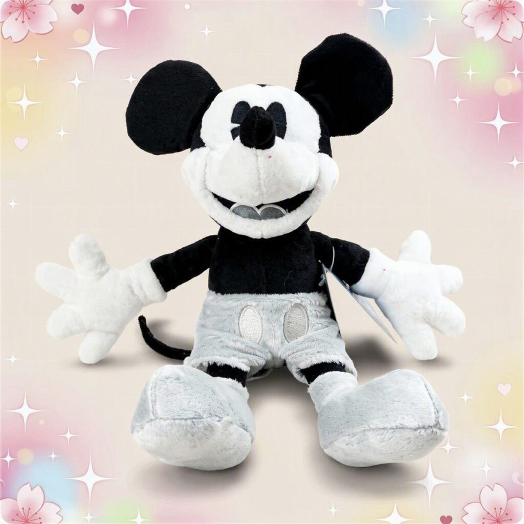 Une peluche Mickey vintage en noir et blanc avec grandes oreilles, gants blancs et grosses chaussures, assise sur un fond pastel décoré d’étoiles et de petites fleurs.