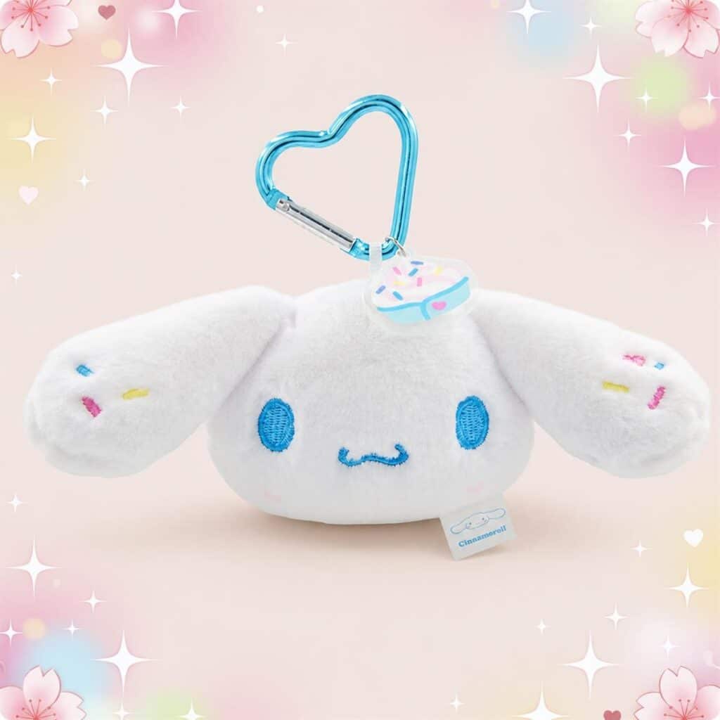 Une peluche Cinnamoroll porte-clés avec mousqueton blanche et douce, avec de grandes oreilles et un mousqueton bleu en forme de cœur, sur fond pastel avec des étoiles.