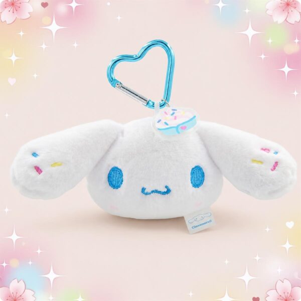 Une peluche Cinnamoroll porte-clés avec mousqueton blanche et douce, avec de grandes oreilles et un mousqueton bleu en forme de cœur, sur fond pastel avec des étoiles.