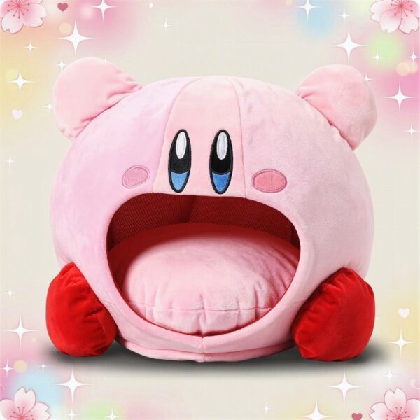 Une peluche Kirby à la bouche grande ouverte avec coussin rose, douce et ronde, avec de petites joues roses et des pieds rouges, posée sur un fond pastel scintillant.