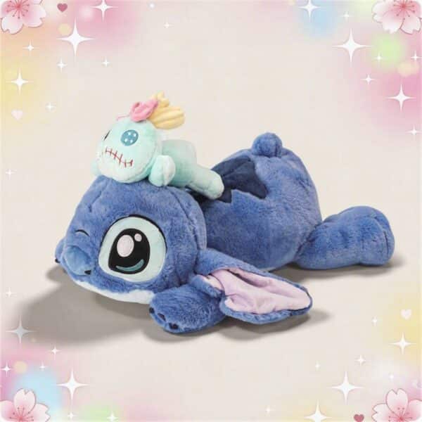 Une peluche Stitch et scrump allongés grand format bleue, avec Scrump posé sur son dos, sur un fond doux pastel et scintillant.