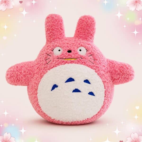 Une peluche Totoro rose douce et ronde, avec de grandes oreilles, un ventre blanc et un fond pastel rempli d’étoiles et de petites fleurs.
