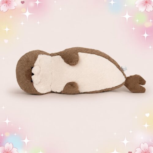 Une Peluche Loutre allongée irrésistible en forme de loutre marron et blanche, couchée sur le dos sur un fond rose pastel avec de petites étoiles brillantes.