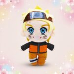 Une peluche Naruto avec visage souriant, cheveux blonds, bandeau bleu et tenue orange, sur un fond pastel décoré de cœurs et d’étoiles.