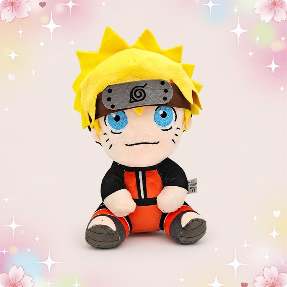 Une peluche Naruto Uzumaki position assise, avec cheveux jaunes, grand bandeau et tenue orange et noire, assise au centre sur un fond rose décoré de petites étoiles et fleurs.