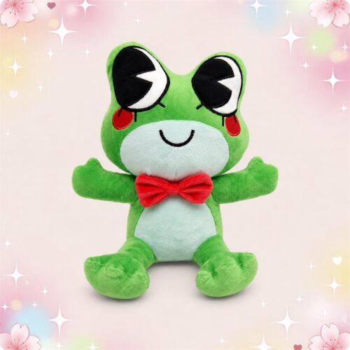 Une peluche grenouille Ribbit aux grands yeux verte avec un nœud papillon rouge, assise sur un fond pastel décoré de petites étoiles et fleurs.