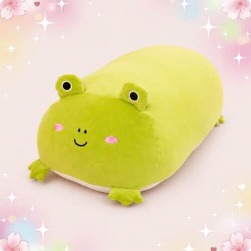 Une peluche grenouille squishy toute en longueur verte, toute douce et rigolote, posée sur un fond rose avec des petites fleurs et des étoiles brillantes.