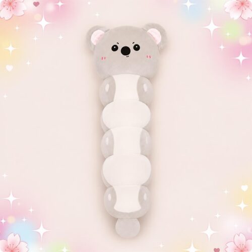 Une peluche Koala grise en forme de long coussin doux, avec un visage mignon et des parties blanches, posée sur un fond rose pastel décoré d’étoiles et de petits cœurs.