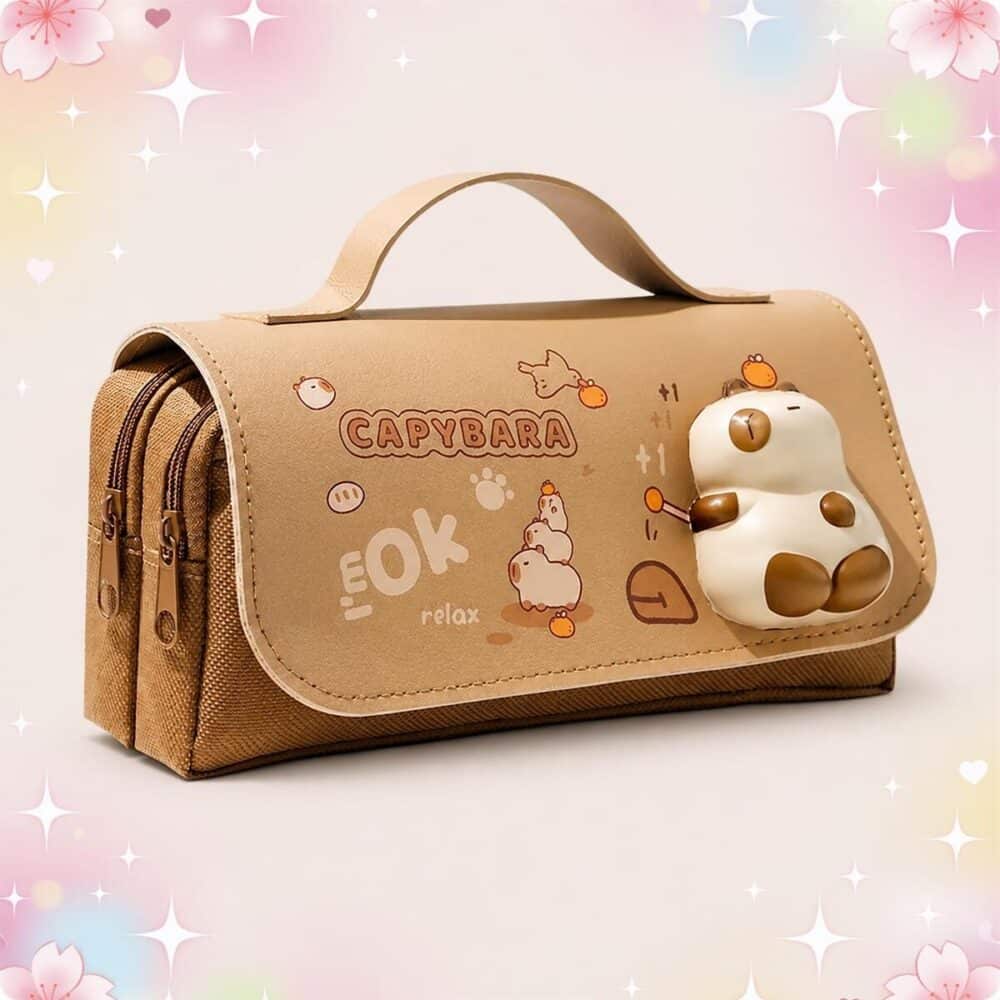 Une Trousse Kawaii en forme de capybara marron avec poignée, décorée d’un petit capybara en relief, posée sur un fond pastel avec des étoiles.
