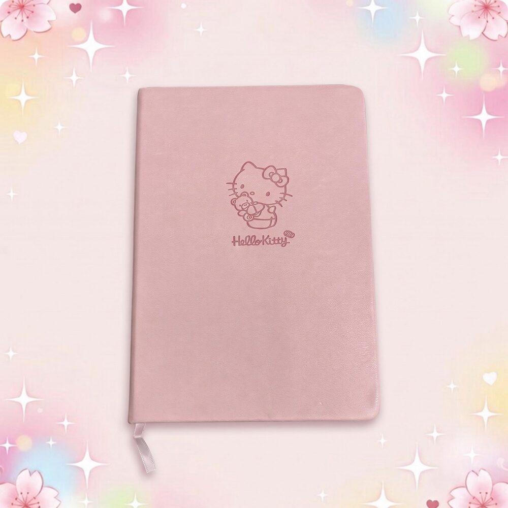 Un carnet kawaii rose Hello Kitty à la couverture rose poudré, avec un petit dessin Hello Kitty au centre et un fond doux décoré d’étoiles et de fleurs.