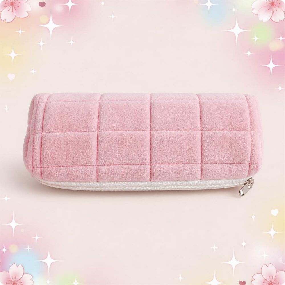 Une trousse Kawaii matelassée en format rectangulaire rose, douce et rembourrée, avec fermeture éclair, sur un fond pastel décoré d’étoiles et de fleurs.