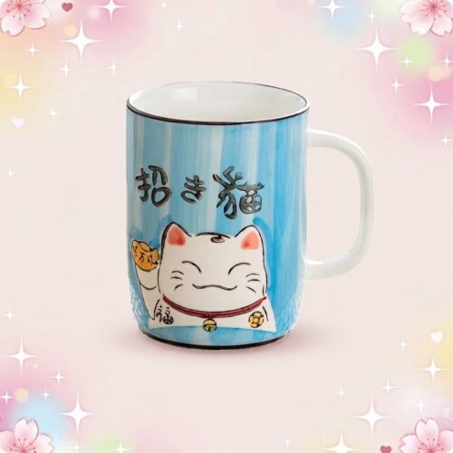 Une tasse kawaii en céramique à motif chat porte bonheur bleue, avec un chat blanc souriant, sur un fond rose décoré d’étoiles et de fleurs.