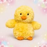 Une peluche canard fluffy jaune toute douce avec un bec et des pattes orange, posée sur un fond pastel décoré de petites étoiles et de cœurs.