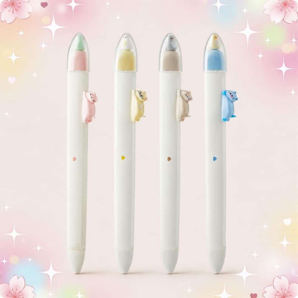 Quatre stylo Kawaii chaton aimanté à pression rétractable blancs, avec un petit chaton coloré au sommet et sur le côté, posés sur un fond rose pastel décoré de cœurs et d’étoiles.