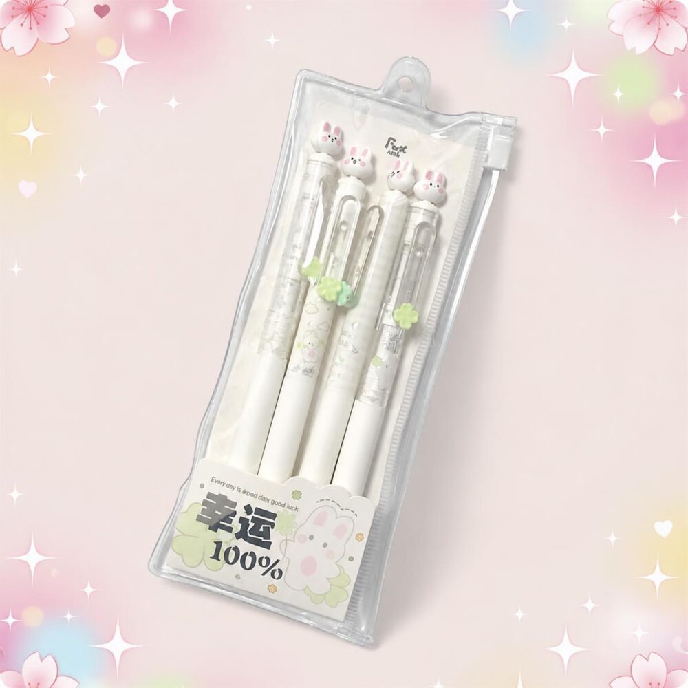Un stylo Kawaii lapin livré avec son sac de rangement, présenté dans une pochette transparente avec quatre stylos blancs décorés de petits lapins, sur un fond rose pastel.
