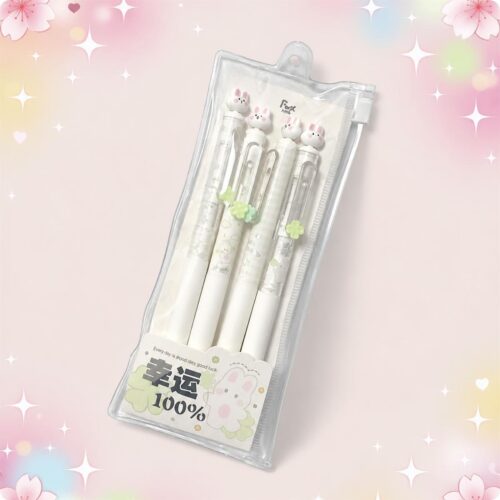 Un stylo Kawaii lapin livré avec son sac de rangement, présenté dans une pochette transparente avec quatre stylos blancs décorés de petits lapins, sur un fond rose pastel.