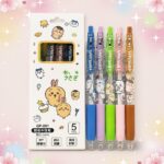 Cinq stylos de couleur kawaii avec un stylo Kawaii rechargeable pour un usage quotidien, présentés dans une boîte décorée de petits dessins mignons sur fond rose.