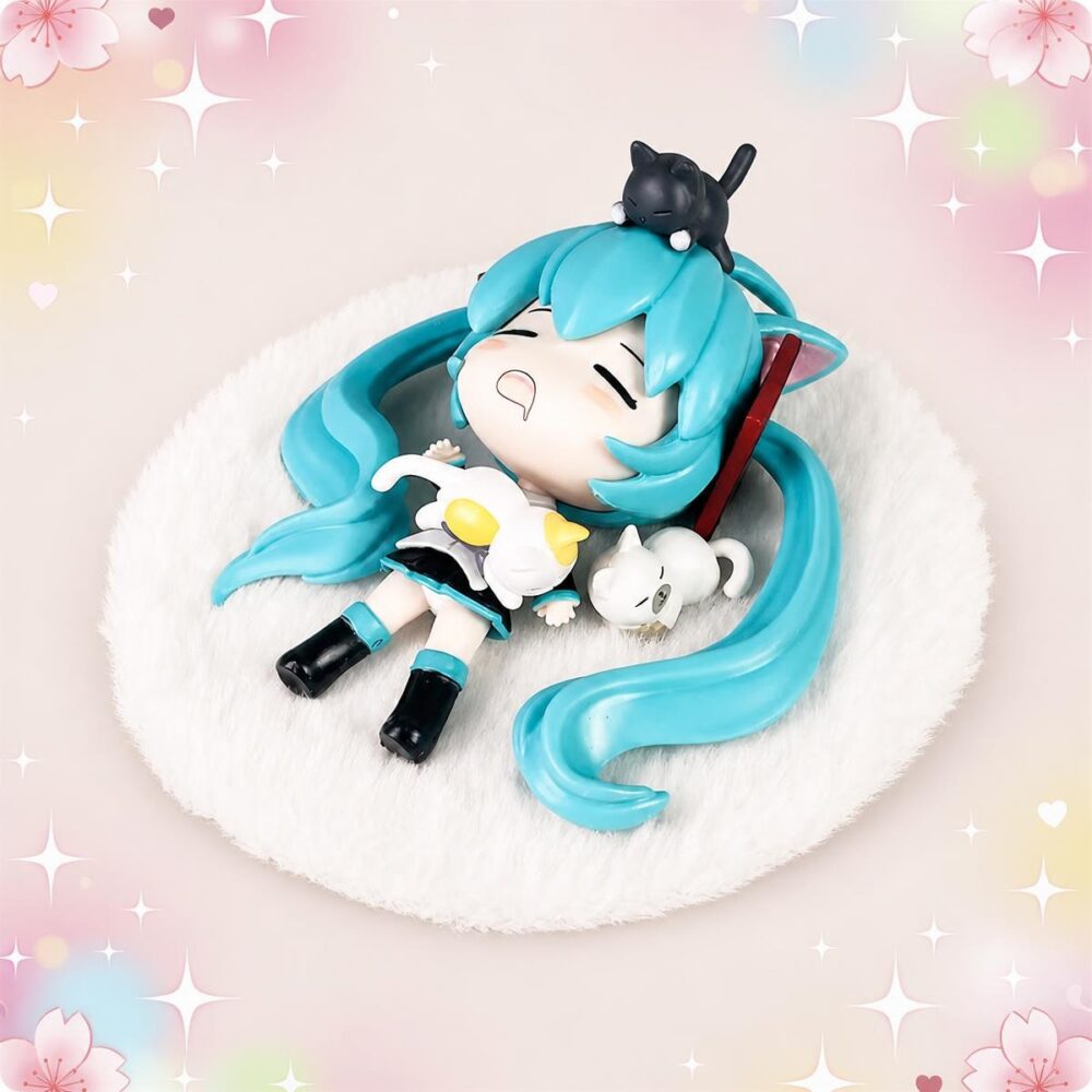 Une Figurine kawaii Hatsune Miku endormie avec de longs cheveux turquoise, allongée sur un coussin blanc moelleux, avec un petit chat noir sur la tête et un fond rose décoré d’étoiles.