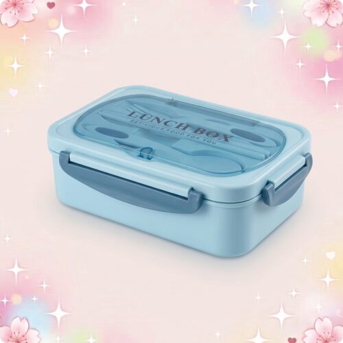 Une lunchbox kawaii isotherme avec couverts inclus bleue, avec couvercle transparent et poignées grises, posée sur un fond rose pastel décoré d’étoiles et de petits cœurs.