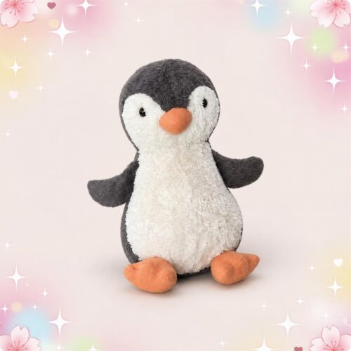 Une peluche Jellycat Peanut Penguin gris et blanc, avec un bec et des petites pattes orange, assise sur un fond pastel décoré d’étoiles et de fleurs.