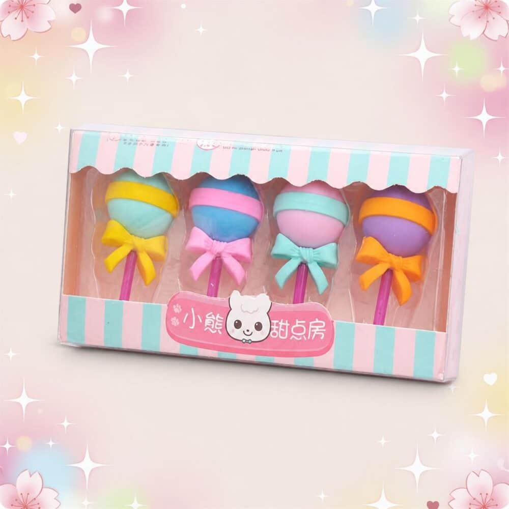 Une boîte de Gomme Kawaii imitant une sucette bien ronde lot de 3 boites, avec quatre gommes colorées en forme de sucette à ruban, sur un fond rose décoré d’étoiles.