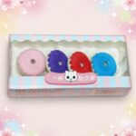 Une boîte de Gomme Kawaii ressemblant à un donut lot de 3 boites, avec quatre gommes rondes rose, violette, rouge et bleue sur un fond pastel.