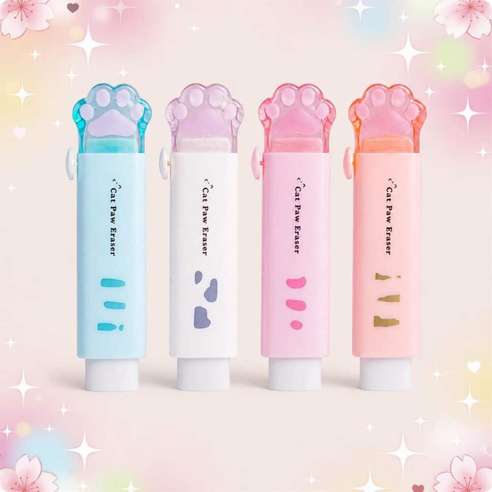 Quatre gommes Kawaii rétractable en forme de patte de chat, en bleu, blanc, rose et orange, posées sur un fond pastel décoré de cœurs et d’étoiles.