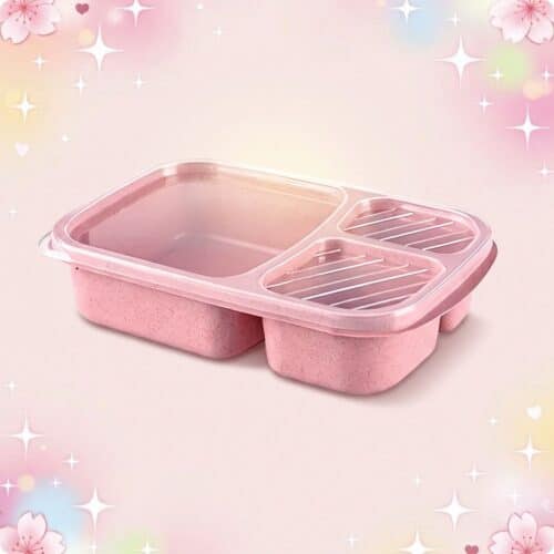 Une lunchbox kawaii à coloris pastel en blé recyclé rose, avec trois compartiments et un couvercle transparent, posée sur un fond doux décoré d’étoiles et de petites fleurs.