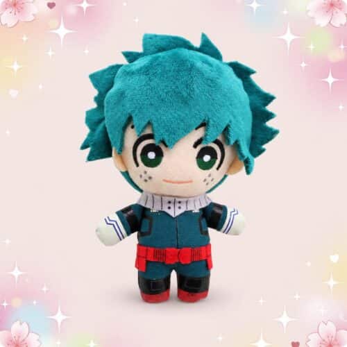 Une peluche anime Izuku Midoriya version porte-clés, représentant un petit personnage aux cheveux bleus et à l’uniforme vert, sur un fond rose décoré de cœurs et d’étoiles.