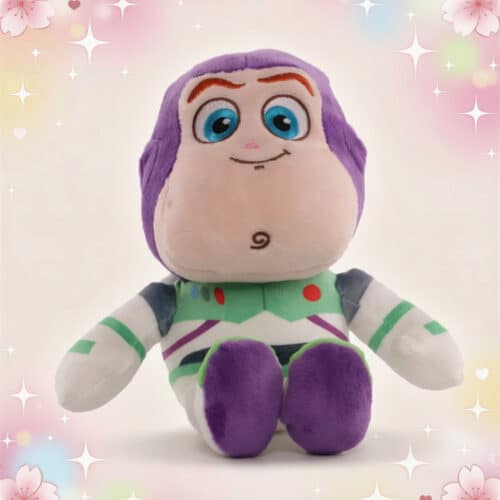 Une peluche Disney Buzz l'Eclair de Toy Story assise, avec combinaison blanche, verte et violette, sur un fond clair décoré de petites étoiles et de cœurs.