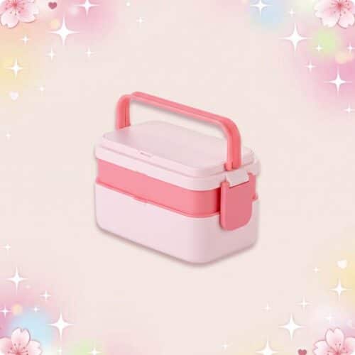 Un bento kawaii coloris pastel rose et blanc, avec poignée et fermeture latérale, posé sur un fond doux décoré d’étoiles scintillantes et de fleurs.
