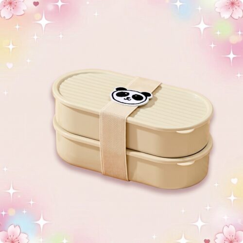 Un bento kawaii à motif panda beige à deux compartiments, fermé par une sangle avec un petit panda, posé sur un fond rose doux et scintillant.