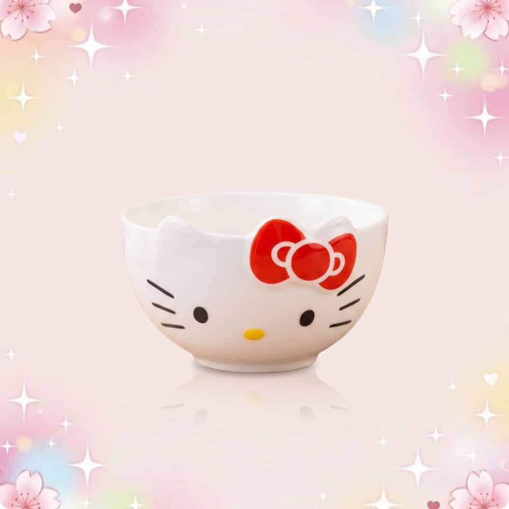 Un bol blanc Hello Kitty de vaisselle kawaii, avec un visage mignon, un nœud rouge et un fond rose décoré d’étoiles et de fleurs.