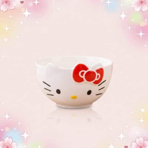 Un bol blanc Hello Kitty de vaisselle kawaii, avec un visage mignon, un nœud rouge et un fond rose décoré d’étoiles et de fleurs.