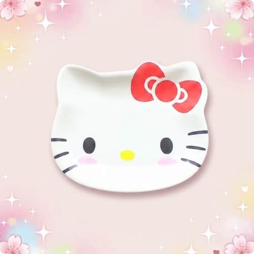 Une vaisselle kawaii motif dessin animé en forme de tête de chat blanc, avec un nœud rouge et un fond rose scintillant.
