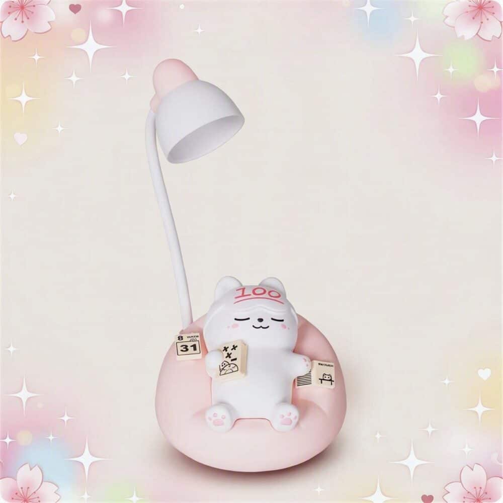 Une lampe kawaii en forme de chat pour bureau étudiant blanche et rose, avec un petit chat assis sur sa base, dans un décor doux et lumineux.