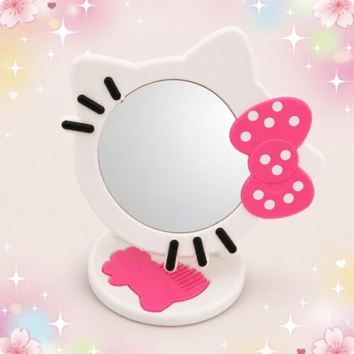 Un miroir Kawaii Hello Kitty blanc avec peigne intégré, en forme de tête de Hello Kitty, décoré d’un nœud rose, posé sur un fond rose doux.