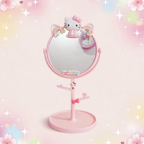 Un miroir kawaii Hello Kitty rose sur pied avec plateau, décoré de petits arcs-en-ciel et de cœurs, posé sur un fond rose doux.