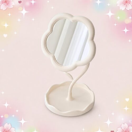 Un miroir kawaii pastel en forme de fleur pour bureau, avec un support assorti, posé sur un fond rose tendre décoré de petites étoiles et fleurs.