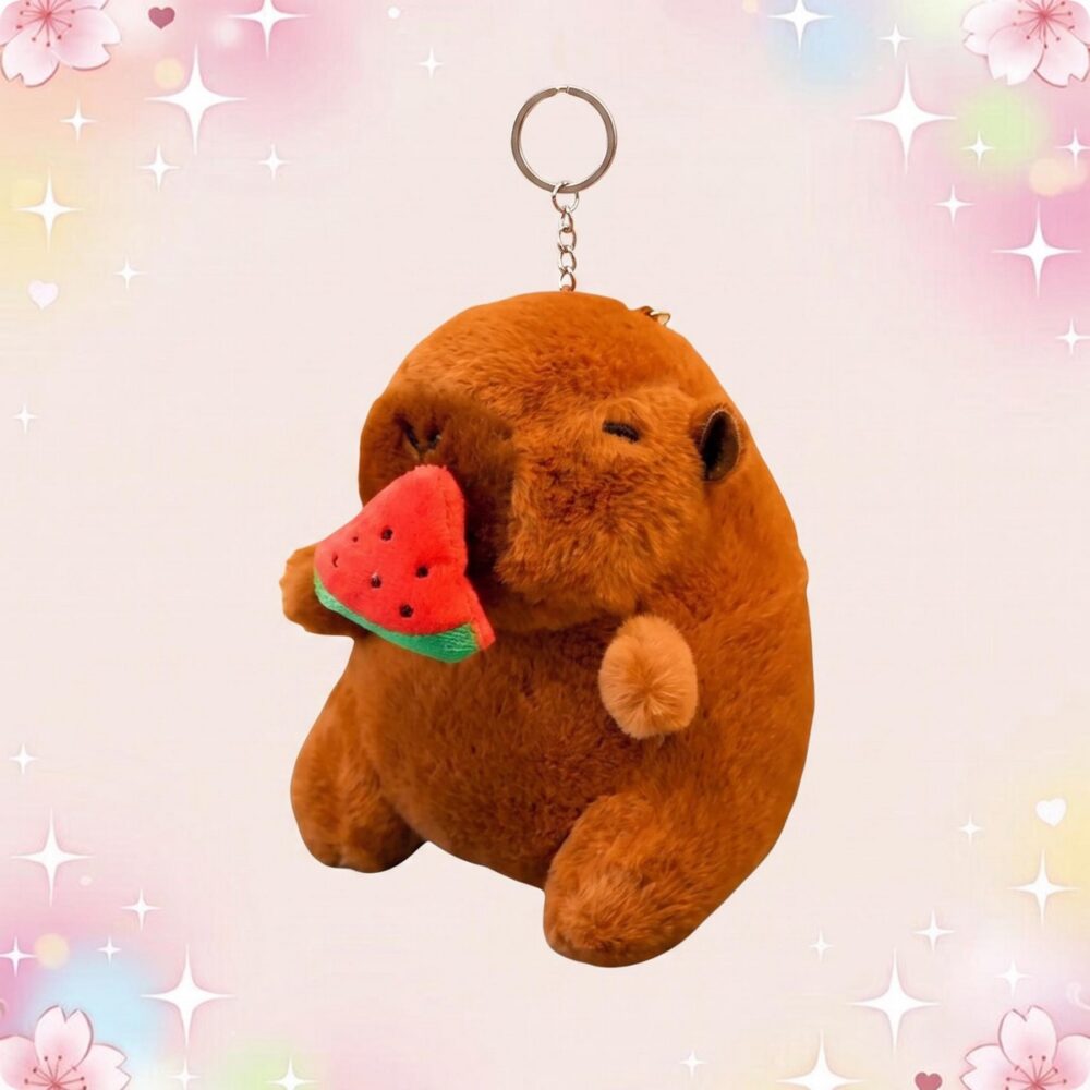 Un porte-clef peluche capybara mangeant une pastèque, doux et marron, suspendu à un anneau métallique sur fond rose avec des étoiles brillantes.