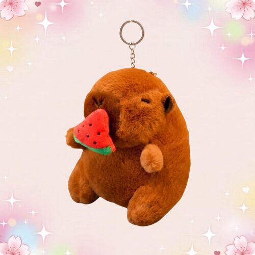 Un porte-clef peluche capybara mangeant une pastèque, doux et marron, suspendu à un anneau métallique sur fond rose avec des étoiles brillantes.