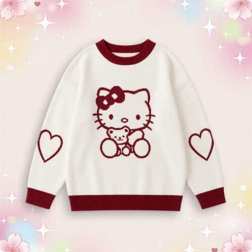 Un pull kawaii Hello Kitty blanc et rouge avec motif Hello Kitty, col et bords bordeaux, posé sur un fond rose pastel décoré de cœurs et d’étoiles.