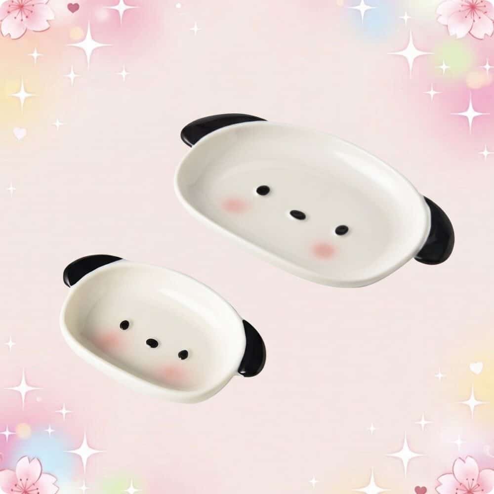 Deux petites assiettes de vaisselle kawaii assiette chiot mignon en forme de visage de chiot, avec des oreilles noires et des joues roses, sur un fond pastel rempli d’étoiles et de fleurs.