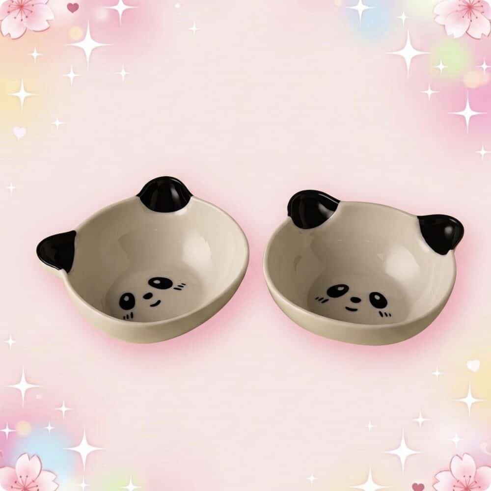 Un lot de 2 bols panda de la vaisselle kawaii, avec petits visages de panda noirs et blancs, posés sur un fond rose doux et brillant.