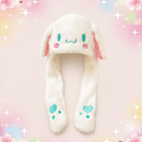 Un bonnet Kawaii Cinnamoroll blanc en peluche aux longues oreilles, doux et tout mignon, avec des broderies bleues et roses sur fond pastel.