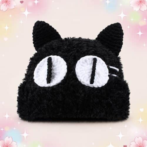Un bonnet Kawaii moelleux à oreilles de chat et grands yeux noir, tout doux, avec deux grandes oreilles pointues et un fond rose décoré de petites étoiles.