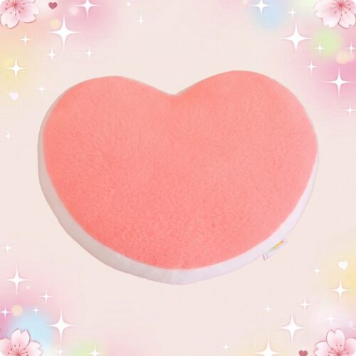 Un coussin kawaii coeur rose en forme de cœur, doux et moelleux, posé sur un fond pastel avec des fleurs et des étoiles scintillantes.