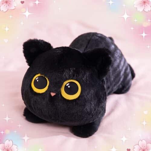 Une peluche chat géante noire, toute douce, avec de grands yeux ronds jaunes et posée sur un fond rose décoré d’étoiles et de fleurs.